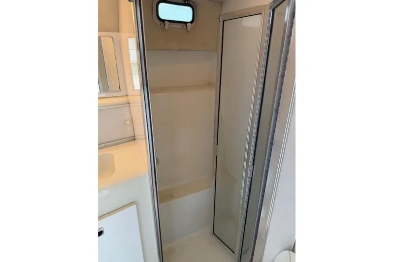 Slide: The Image of 1993 Silverton 34 Convertible yacht bathroom with shower and small window. - 50