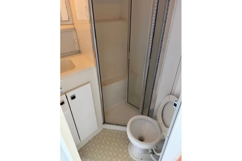 Slide: The Image of 1993 Silverton 34 Convertible boat bathroom with shower, sink, and toilet. - 51
