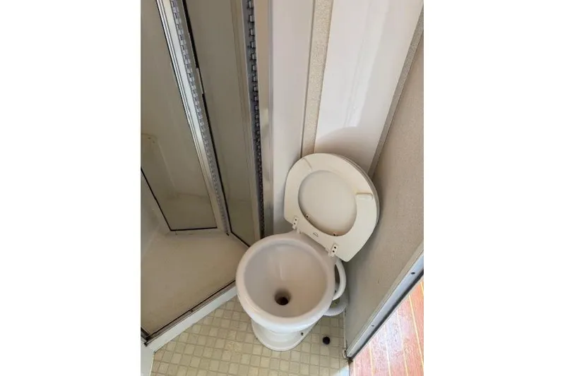 Slide: The Image of 1993 Silverton 34 Convertible boat bathroom with compact toilet and shower. - 52