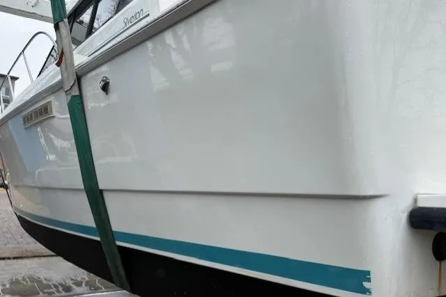 Slide: The Image of 1993 Silverton 34 Convertible boat with white and blue hull, docked and secured. - 7