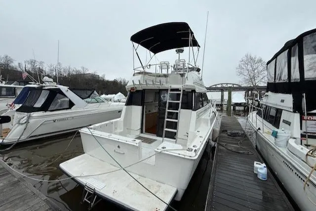 Slide: The Image of 1993 Silverton 34 Convertible boat docked, featuring a spacious deck and flybridge. - 8