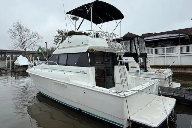 Slide: The Image of 1993 Silverton 34 Convertible boat docked at a marina on a cloudy day. - 9