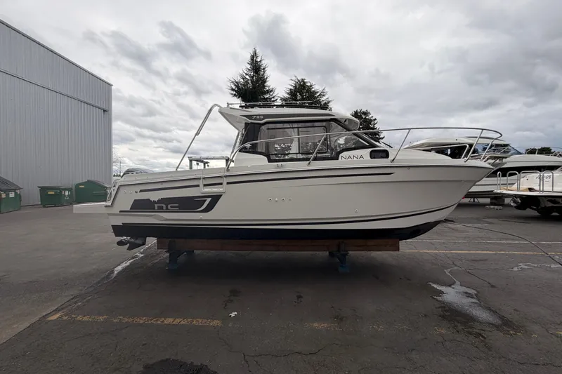 Slide: The Image of 2026 Jeanneau NC Weekender 795 Series 2 boat on display in a marina. - 2