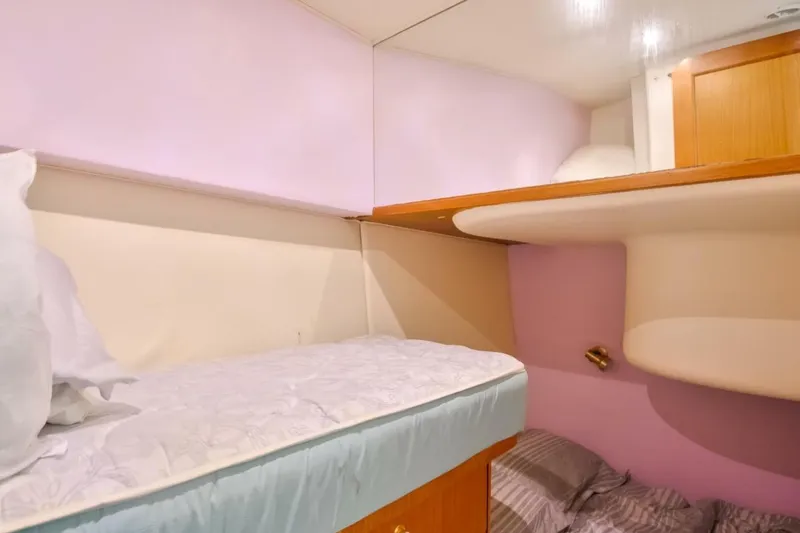 Slide: The Image of 1999 Ocean Yachts 48 Super Sport cabin with cozy bunk beds and soft lighting. - 12