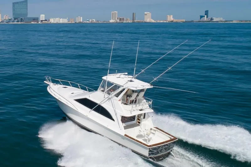 Slide: The Image of 1999 Ocean Yachts 48 Super Sport cruising on open water near city skyline. - 20