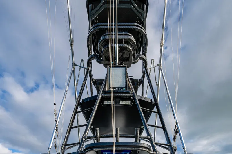 Slide: The Image of 2024 Contender 44 ST boat tower against a cloudy sky, showcasing sleek design and structure. - 26