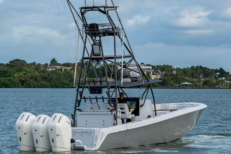 Slide: The Image of 2024 Contender 44 ST boat with triple engines cruising on a scenic waterway. - 4