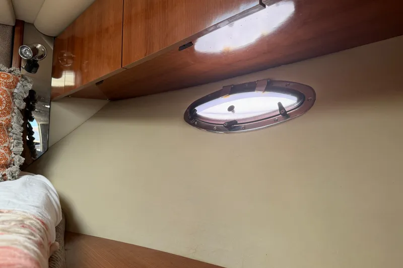 Slide: The Image of Interior cabin of 2008 Cruisers Yachts 330 Express with porthole and wooden cabinetry. - 10