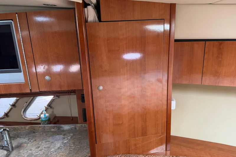 Slide: The Image of Interior of 2008 Cruisers Yachts 330 Express with wooden cabinetry and marble countertop. - 14