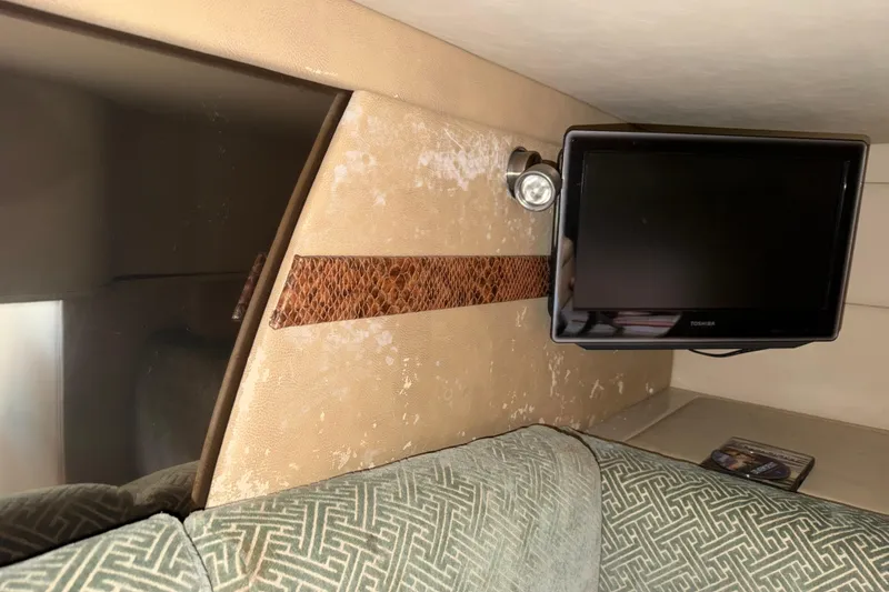 Slide: The Image of 2008 Cruisers Yachts 330 Express interior with TV and patterned upholstery. - 22