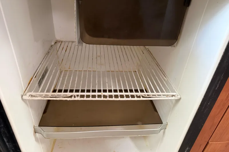 Slide: The Image of Empty refrigerator inside a 2008 Cruisers Yachts 330 Express boat. - 29