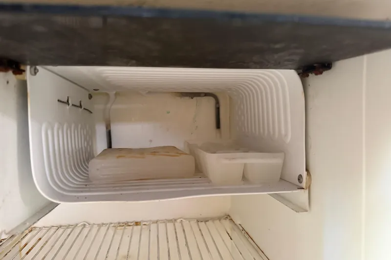Slide: The Image of Empty freezer compartment in 2008 Cruisers Yachts 330 Express, showing ice tray and shelf. - 30