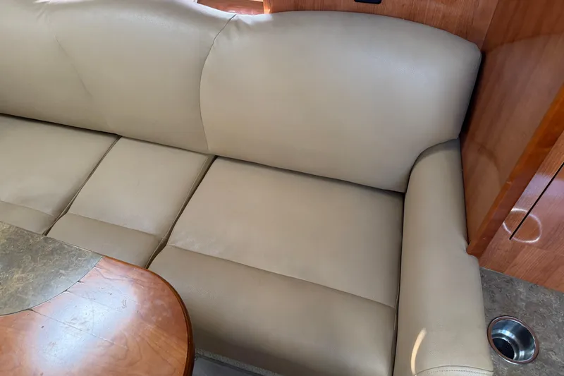 Slide: The Image of Beige leather seating in 2008 Cruisers Yachts 330 Express interior, with wooden table. - 35