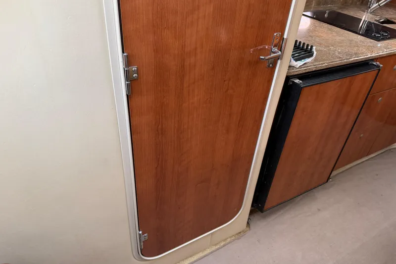 Slide: The Image of 2008 Cruisers Yachts 330 Express interior with wooden door and kitchenette area. - 36