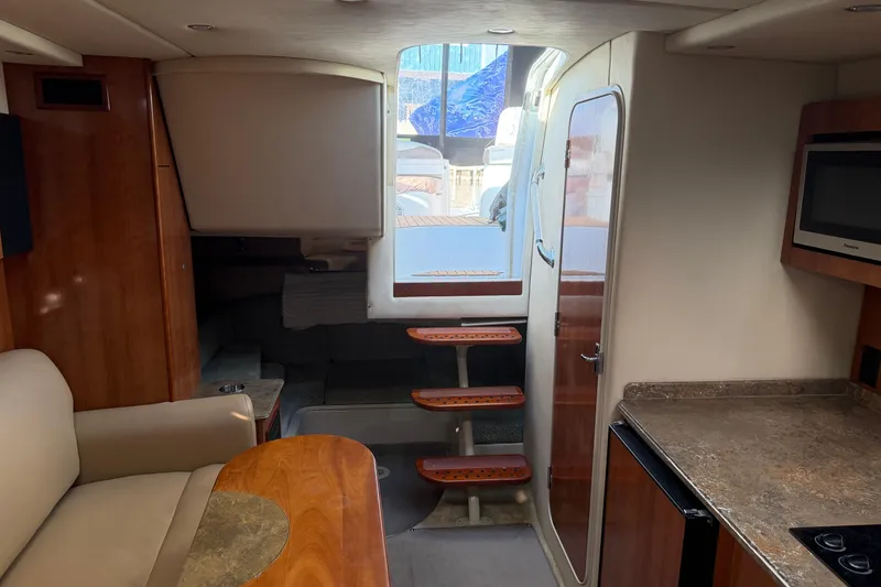 Slide: The Image of 2008 Cruisers Yachts 330 Express interior with seating, kitchenette, and steps to deck. - 37