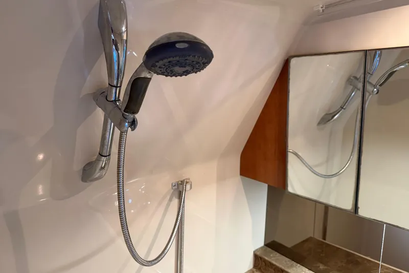 Slide: The Image of Shower area in 2008 Cruisers Yachts 330 Express, featuring chrome fixtures and mirrored cabinet. - 48