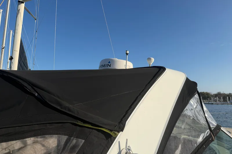 Slide: The Image of 2008 Cruisers Yachts 330 Express with black canopy and Garmin radar, docked under clear skies. - 53