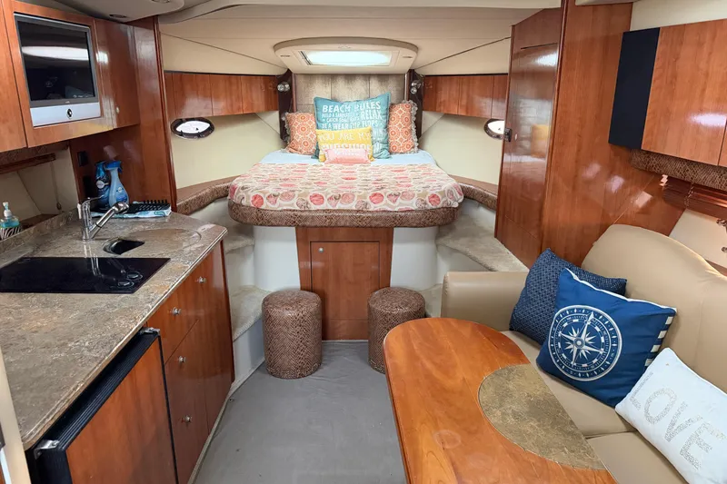Slide: The Image of 2008 Cruisers Yachts 330 Express cabin interior with kitchenette, bed, and seating area. - 61