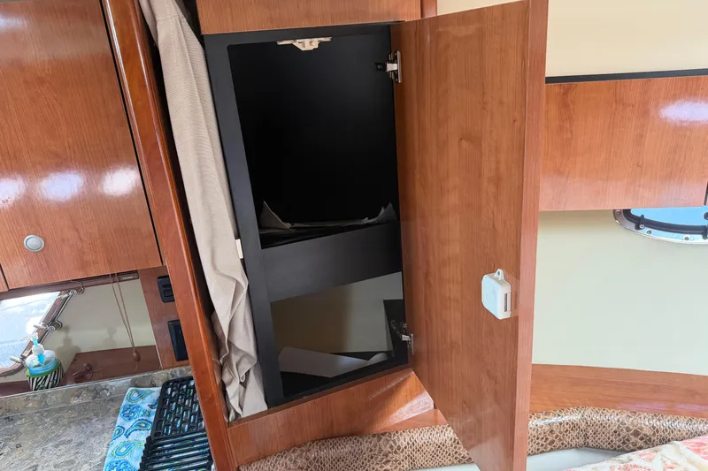 Slide: The Image of 2008 Cruisers Yachts 330 Express interior with open wooden cabinet and countertop. - 7