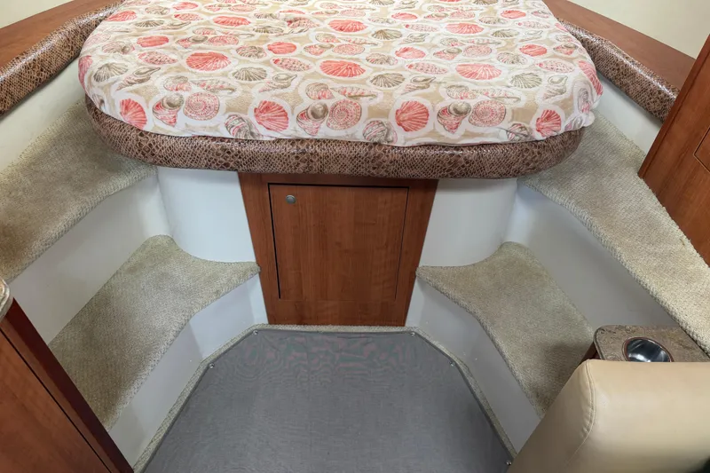 Slide: The Image of 2008 Cruisers Yachts 330 Express cabin interior with patterned bedding and carpeted steps. - 9