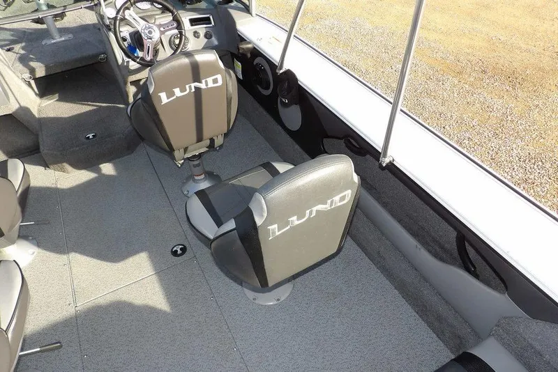 Slide: The Image of 2025 Lund 1875 Crossover XS boat interior with branded seats and steering wheel. - 14