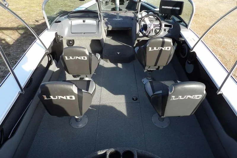 Slide: The Image of 2025 Lund 1875 Crossover XS boat interior with four branded seats and steering console. - 17