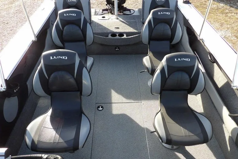 Slide: The Image of 2025 Lund 1875 Crossover XS boat interior with four black and gray seats. - 19