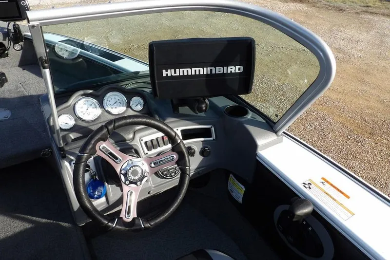 Slide: The Image of 2025 Lund 1875 Crossover XS boat dashboard with Humminbird display and steering wheel. - 26