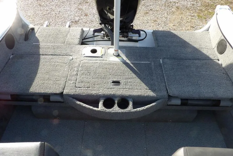 Slide: The Image of 2025 Lund 1875 Crossover XS boat interior with carpeted deck and cup holders. - 3