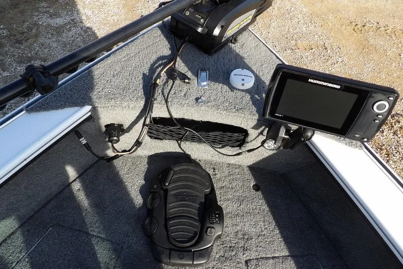 Slide: The Image of 2025 Lund 1875 Crossover XS boat dashboard with fishfinder and foot pedal controls. - 36