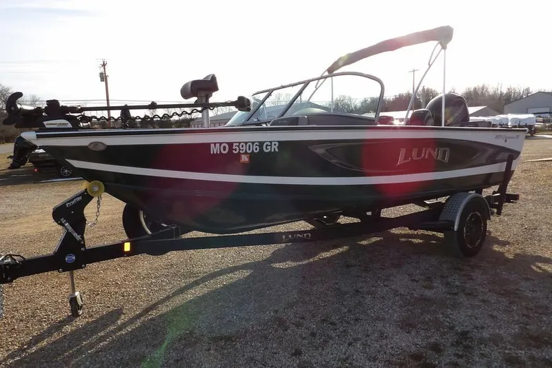 Slide: The Image of 2025 Lund 1875 Crossover XS boat on trailer, parked outdoors. - 4