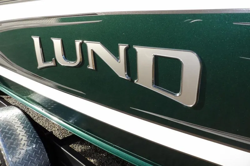 Slide: The Image of Close-up of 2025 Lund 1875 Crossover XS boat logo on green surface. - 48