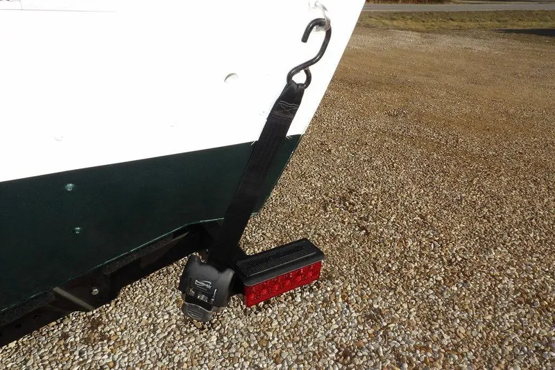 Slide: The Image of 2025 Lund 1875 Crossover XS boat trailer with safety strap and red reflector. - 51