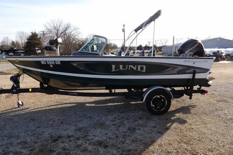 Slide: The Image of 2025 Lund 1875 Crossover XS boat on trailer, parked outdoors. - 6