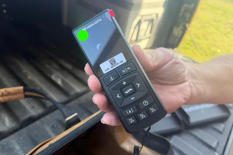 Slide: The Image of Hand holding a Minn Kota remote control for a 2004 PlayCraft 22 Bay Charger boat. - 16