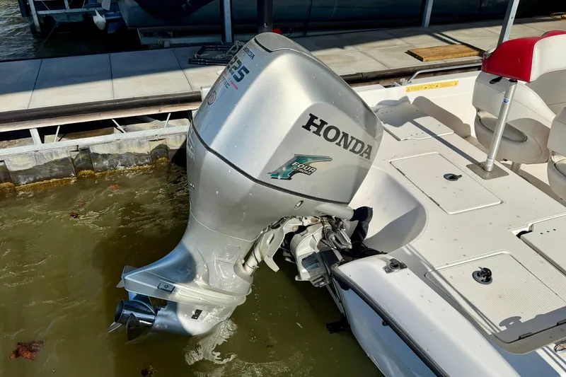 Slide: The Image of 2004 PlayCraft 22 Bay Charger with Honda outboard motor docked by the water. - 17