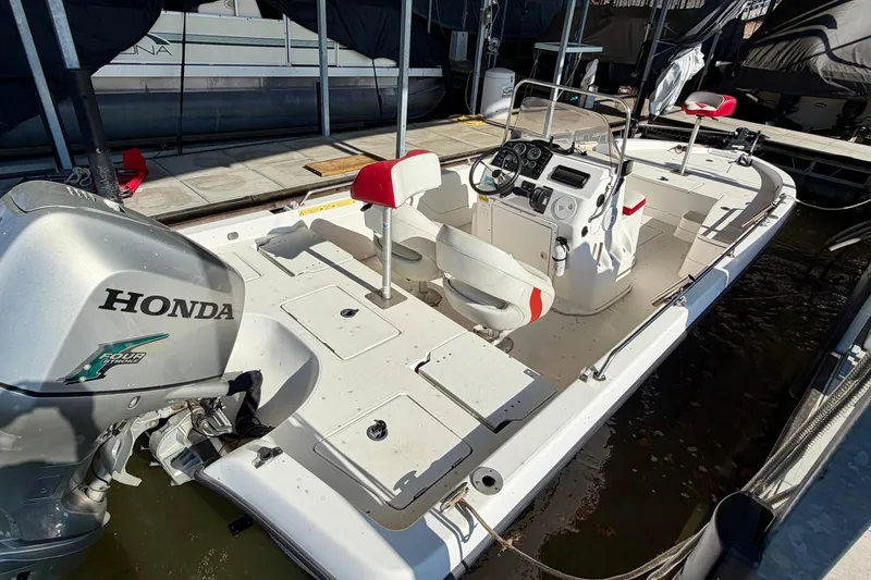 Slide: The Image of 2004 PlayCraft 22 Bay Charger boat with Honda engine, docked in marina. - 2