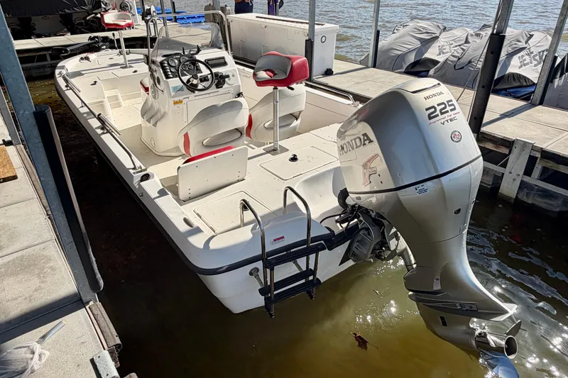 Slide: The Image of 2004 PlayCraft 22 Bay Charger boat with Honda 225 VTEC engine docked by the water. - 21