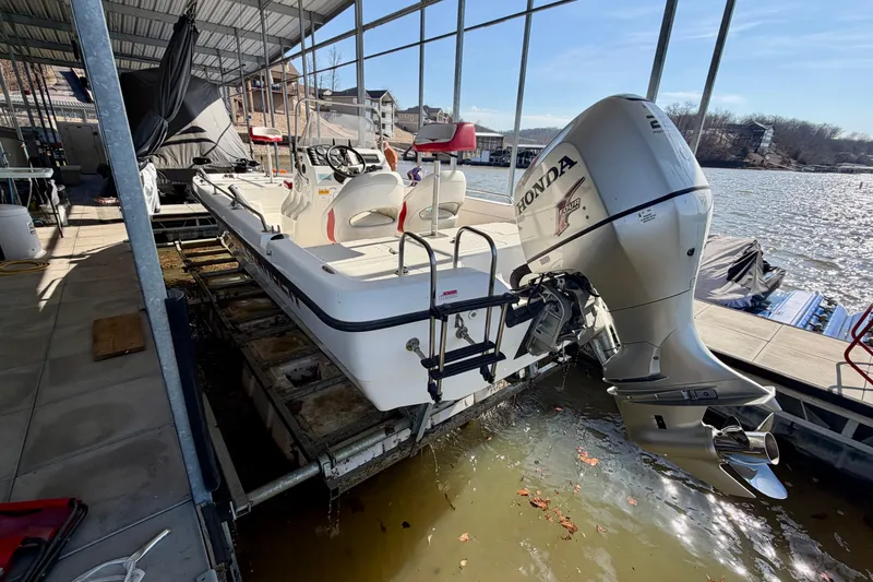 Slide: The Image of 2004 PlayCraft 22 Bay Charger boat with Honda outboard motor docked in a marina. - 23