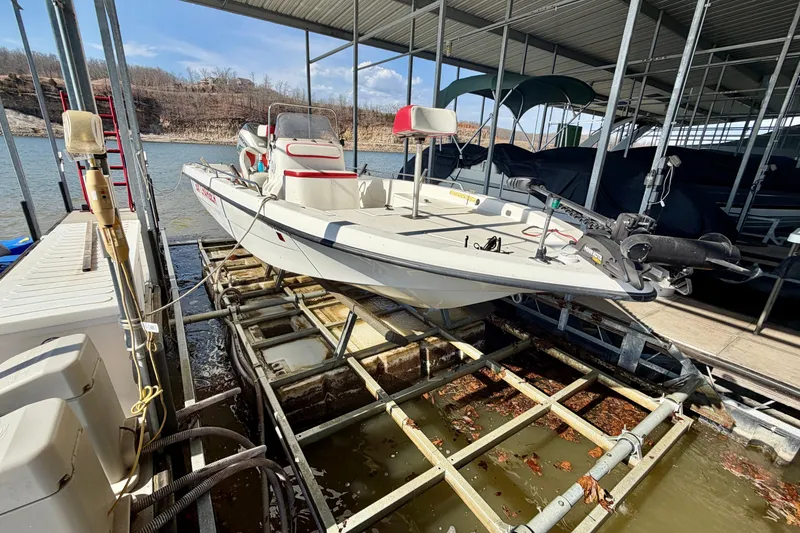 Slide: The Image of 2004 PlayCraft 22 Bay Charger boat docked in a marina, surrounded by water and equipment. - 27
