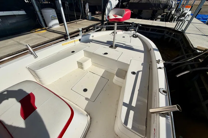 Slide: The Image of 2004 PlayCraft 22 Bay Charger boat interior with red and white seating, docked at marina. - 3