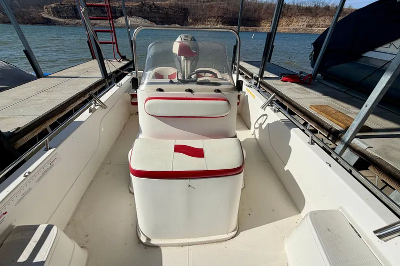 Slide: The Image of 2004 PlayCraft 22 Bay Charger boat interior with red and white seating at dock. - 7