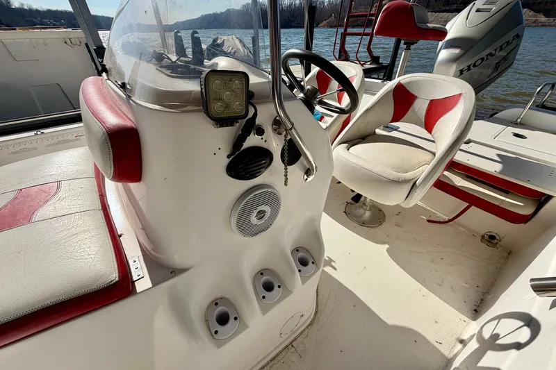 Slide: The Image of 2004 PlayCraft 22 Bay Charger boat interior with steering wheel and seating. - 8