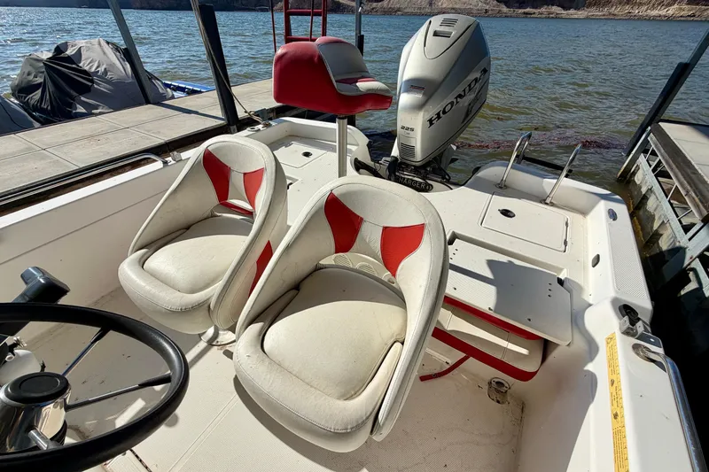 Slide: The Image of 2004 PlayCraft 22 Bay Charger boat interior with Honda engine, featuring red and white seating. - 9