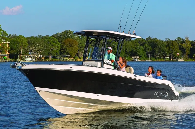 Slide: The Image of Manufacturer Provided Image: 2019 Robalo R242 Explorer boat cruising on a lake with passengers. - 0