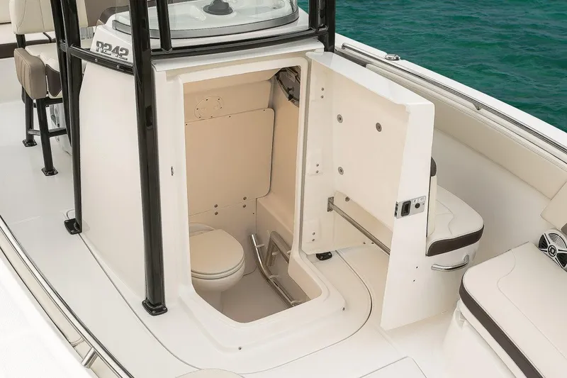 Slide: The Image of Manufacturer Provided Image: 2019 Robalo R242 Explorer boat interior with open bathroom compartment. - 11