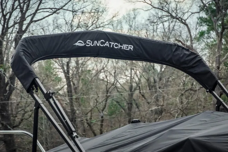 Slide: The Image of SunCatcher Fusion 324RC 2025 boat canopy against a backdrop of trees. - 10