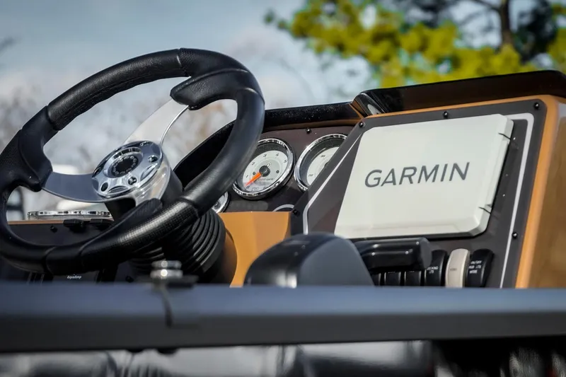 Slide: The Image of Steering wheel and Garmin display on 2025 SunCatcher Fusion 324RC boat dashboard. - 13