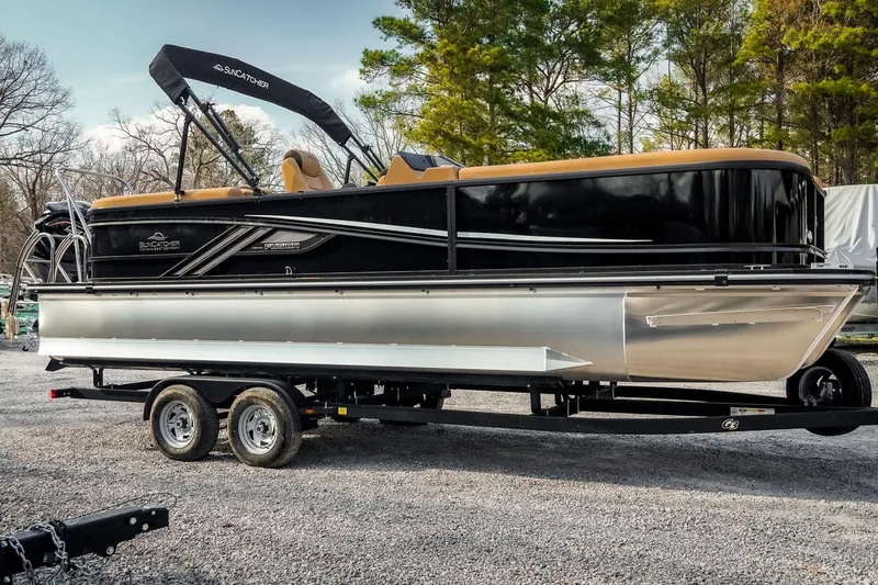 Slide: The Image of 2025 SunCatcher Fusion 324RC pontoon boat on trailer, parked outdoors. - 3