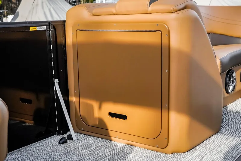 Slide: The Image of 2025 SunCatcher Fusion 324RC boat interior with tan seating and storage compartment. - 31